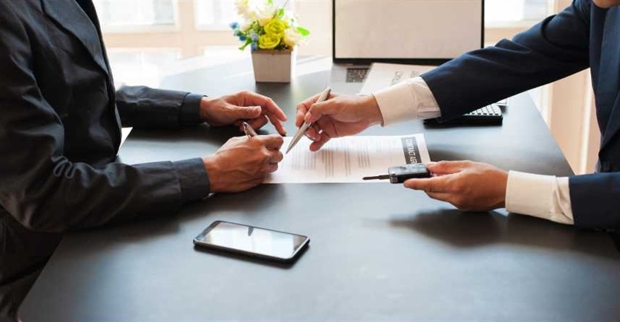 Two peoples hands signing documents