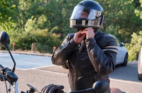 man putting on motorbike helmet